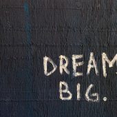 Wat is het verschil tussen manager en management? Foto van een muur met de woorden "dream big"